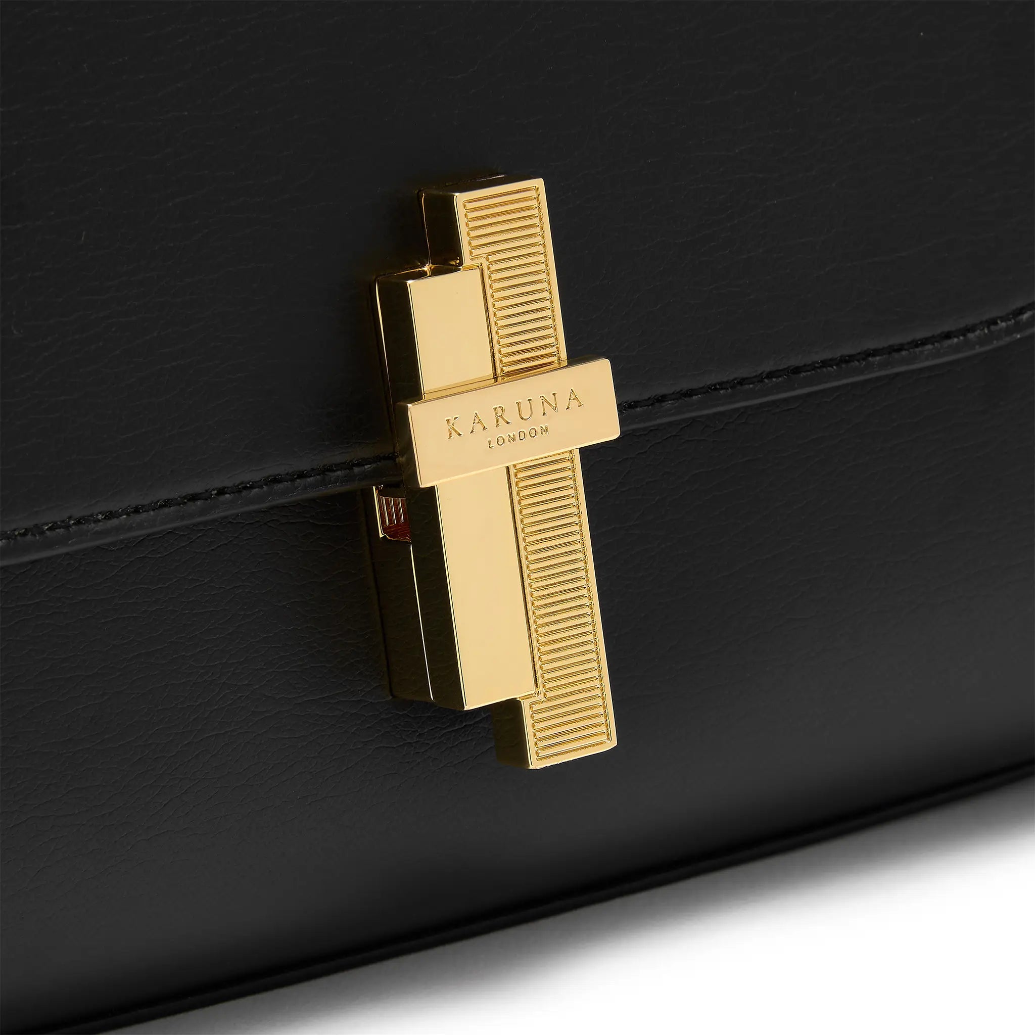 Karuna London Maddox black top handle bag with branded lock