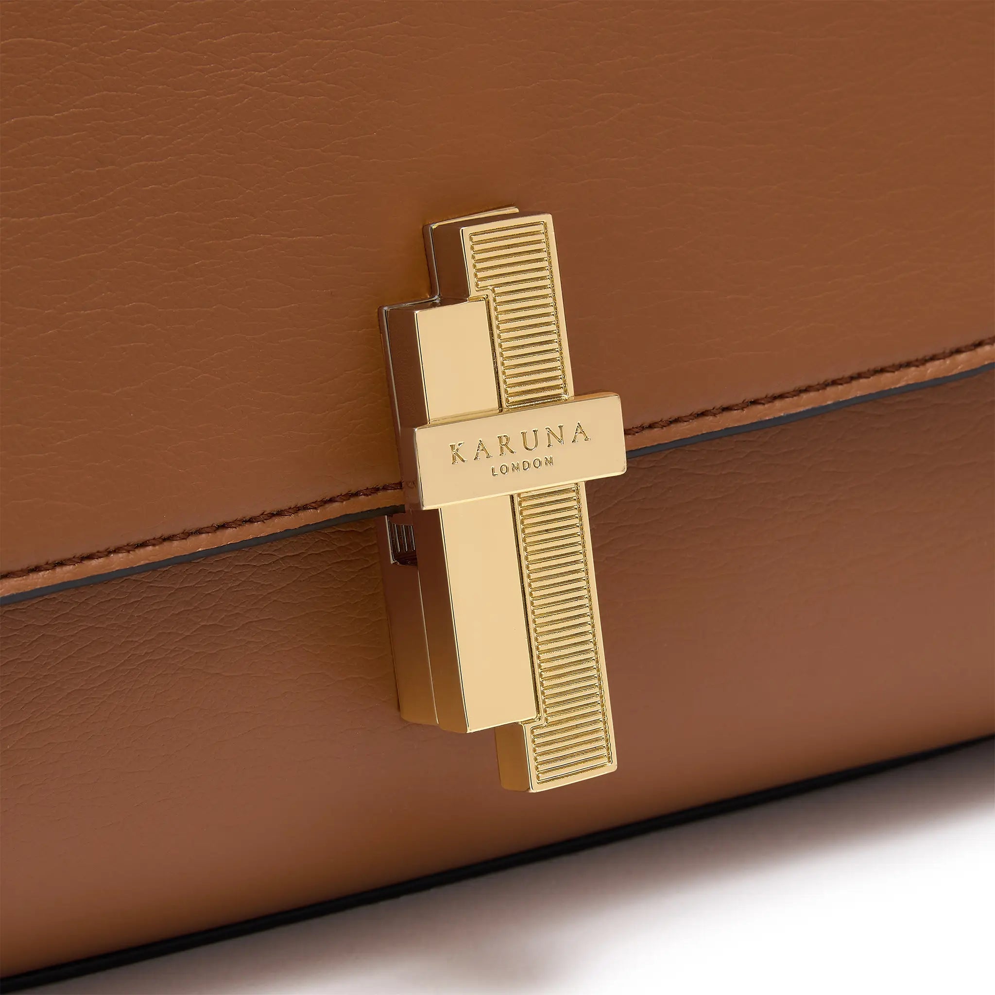 Karuna London Maddox cinnamon top handle bag with branded lock