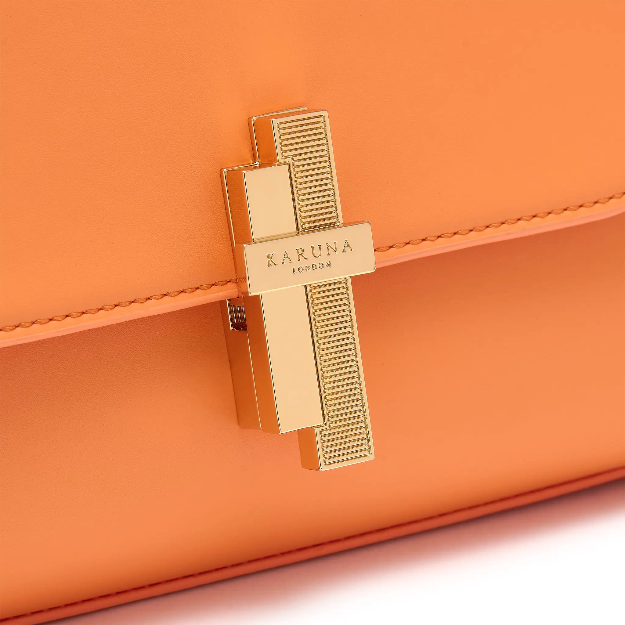 Karuna London Maddox papaya top handle bag with branded lock